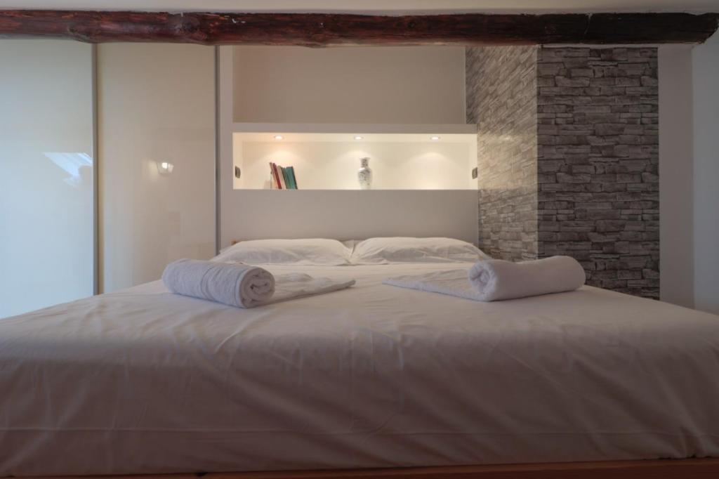a bedroom with a large white bed with towels on it at Bilocale accogliente tra Como e Milano in Saronno