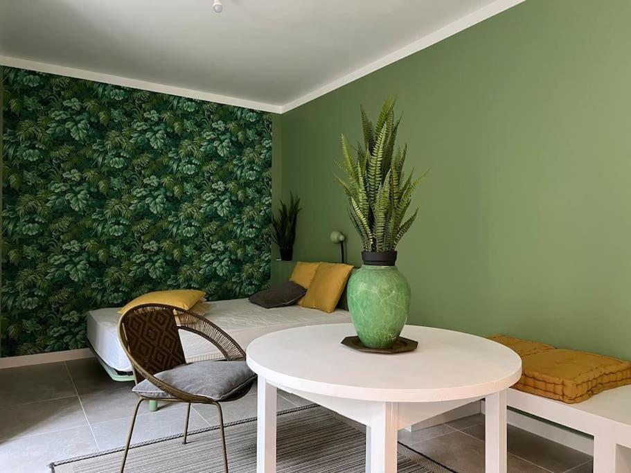 a living room with a vase on a table and a couch at L&#39;Oasis urbaine : détente totale in La Rochelle