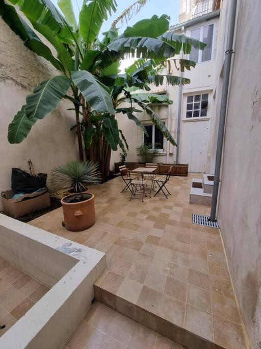 a courtyard with a patio with a table and plants at L&#39;Oasis urbaine : détente totale in La Rochelle