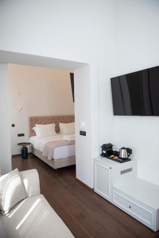 a bedroom with a bed and a tv on the wall at Jensen Luxury Suites in Rhodes Town
