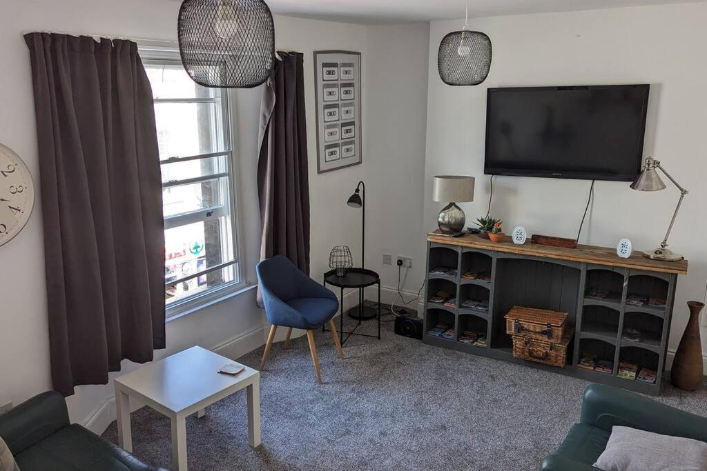 3- Bedroom modern,spacious apartment-Devon في نيوتن أبوت: غرفة معيشة مع تلفزيون وكرسي أزرق