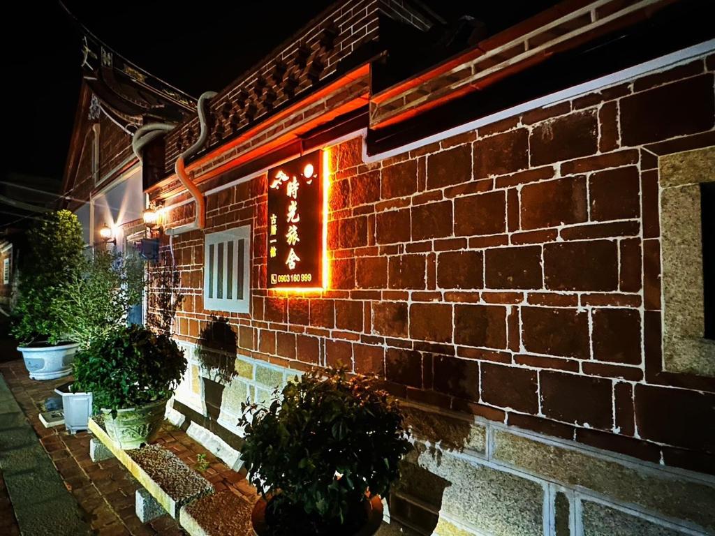 ein Backsteingebäude mit einem Schild an der Seite in der Unterkunft 時光旅舍古厝一館 in Jinning