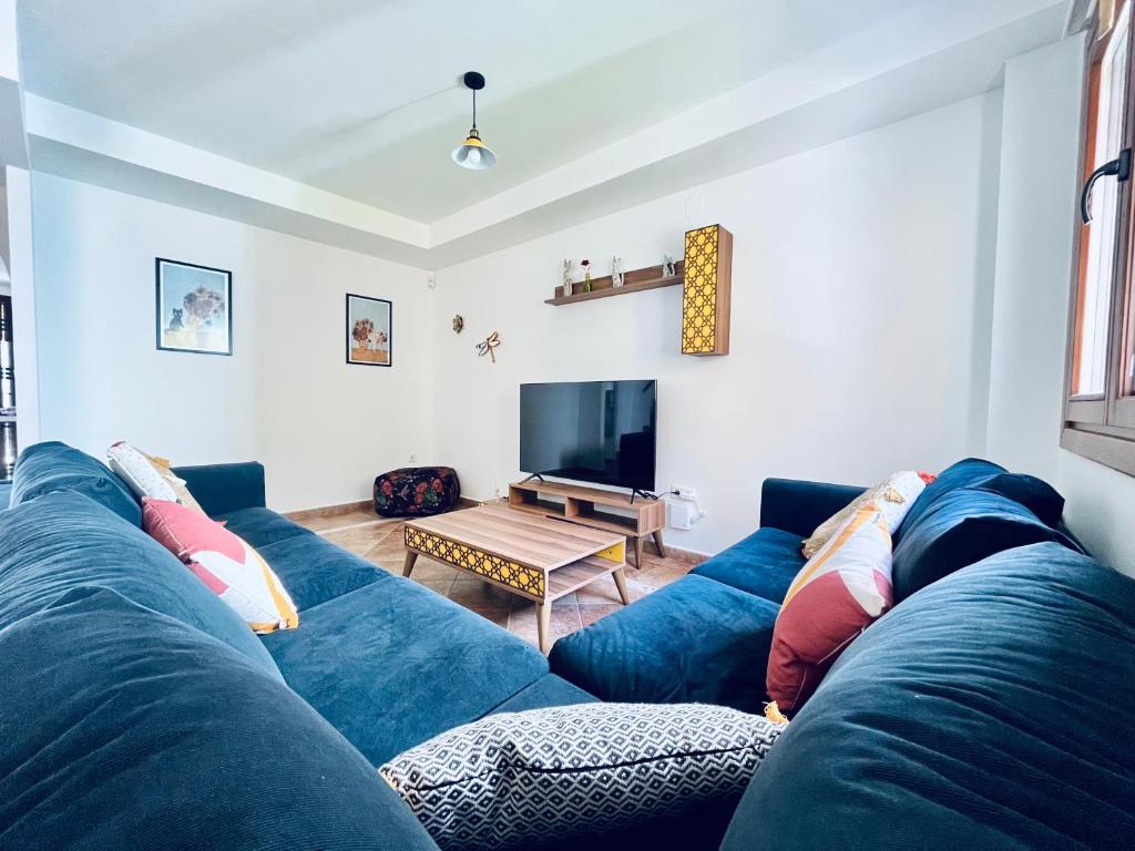 sala de estar con sofá azul y TV en Lomas 62, en Ayamonte