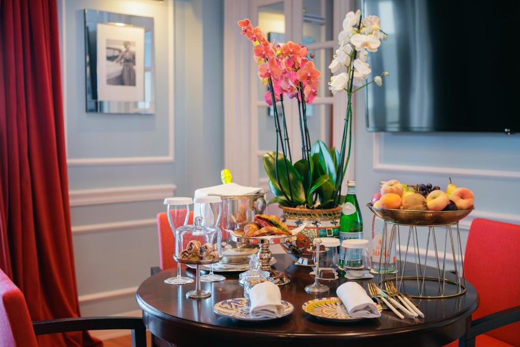 a table with food and drinks and flowers on it at Grand Hotel San Pietro Taormina in Taormina