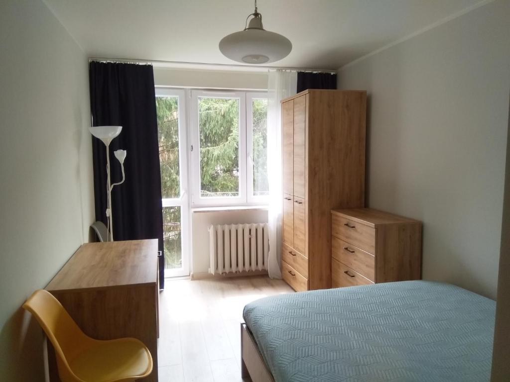 um quarto com uma cama, uma cómoda e uma janela em U Cioci em Cracóvia