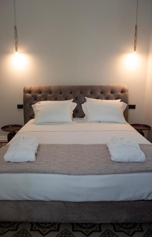 a bedroom with a large bed with two pillows at Jensen Luxury Suites in Rhodes Town