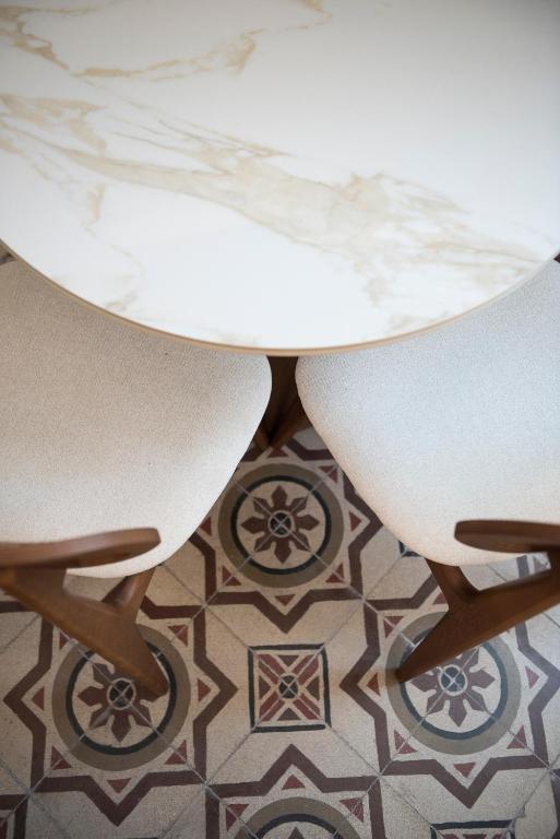 a white table and two chairs on a tile floor at Jensen Luxury Suites in Rhodes Town