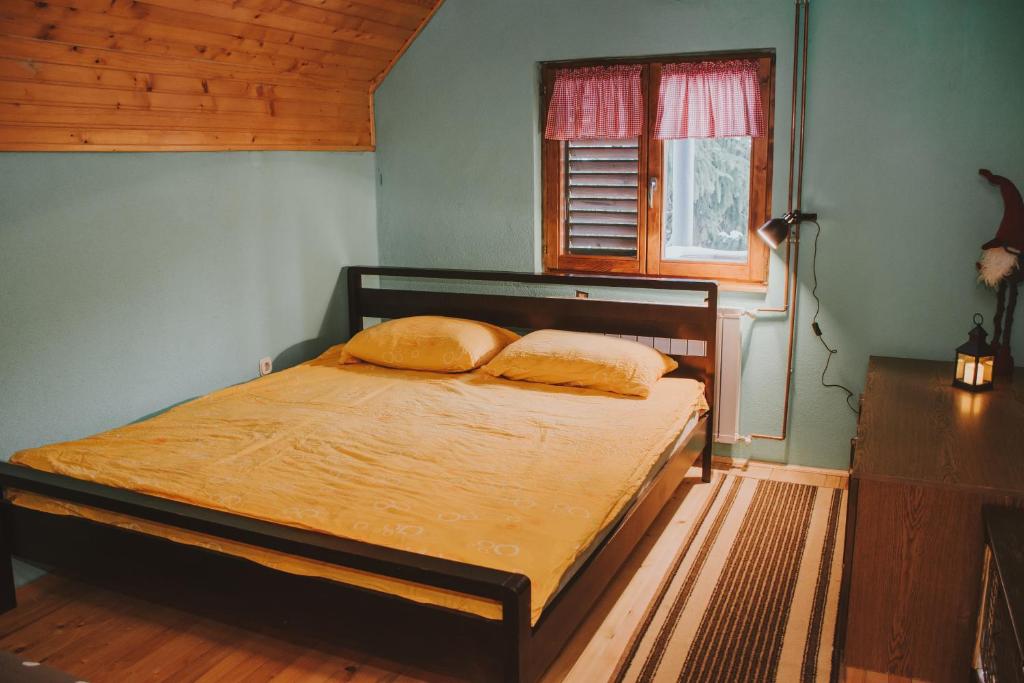 a bedroom with a bed with two pillows on it at Guest house SAMM in Šišava