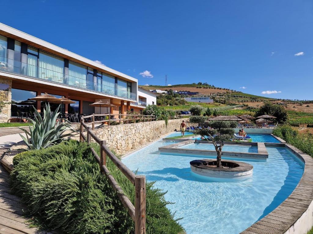 un complejo con 2 piscinas y un edificio en Douro Cister Hotel Resort, en Ucanha
