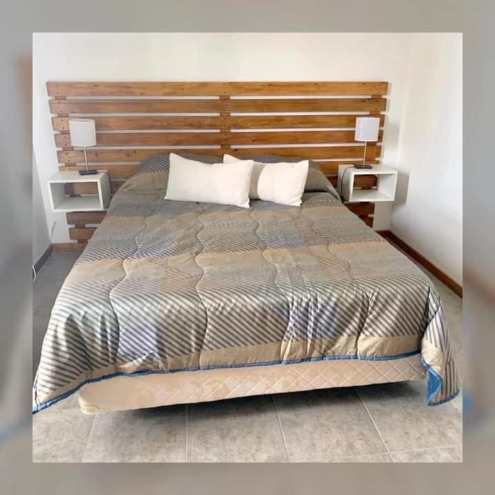 a bedroom with a large bed with two night stands at Margarita Tempo in Esquel