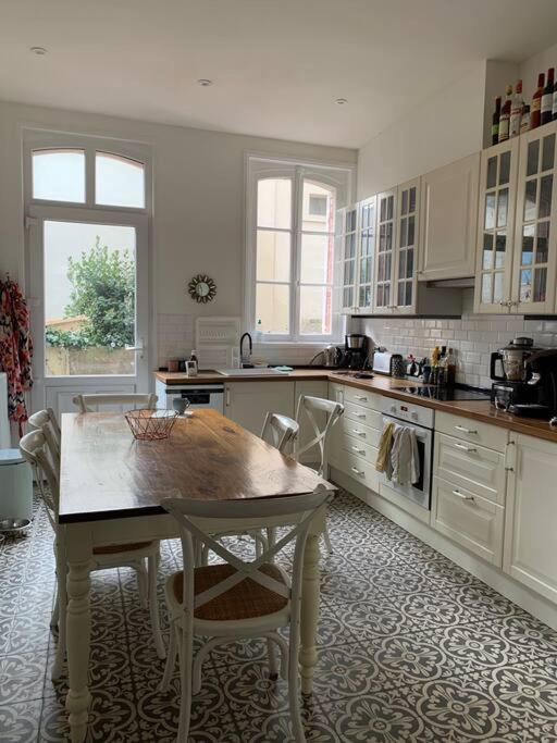 uma cozinha com uma mesa e cadeiras em Maison Serpolette - maison entiere em Trouville-sur-Mer