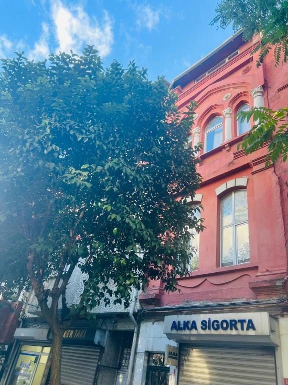 a tree in front of a building with aania storefront at Red House Fatih in Istanbul