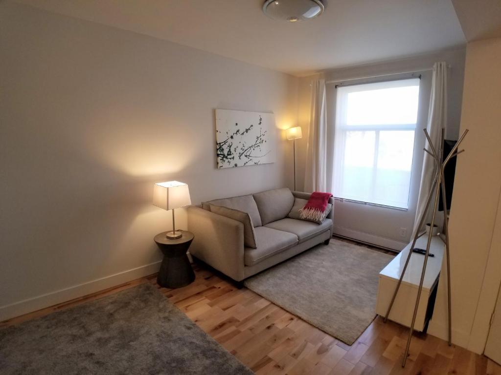 a living room with a couch and a window at 3 bedroom near Olympic Stadium in Montréal