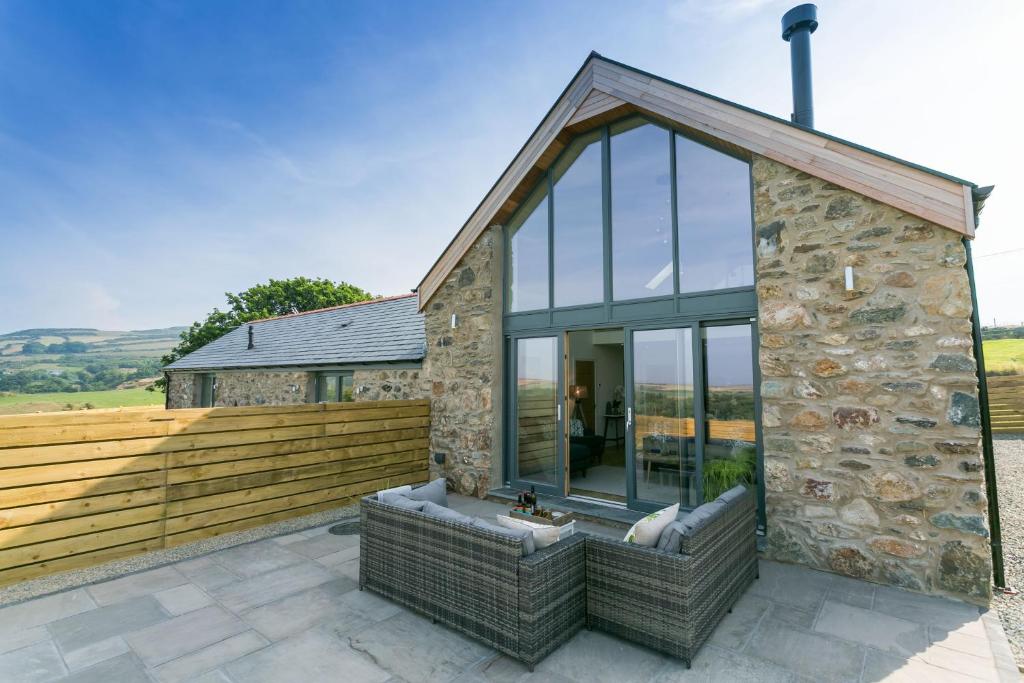 a stone and glass house with a large window at Bwncath in Llanrhwydrys