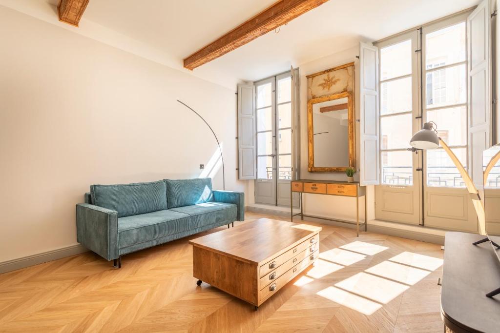 un salon avec un canapé bleu et une table basse dans l'établissement Magnifique appartement centre historique, à Aix-en-Provence