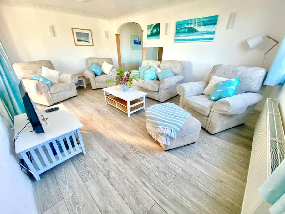 a living room with couches and a tv in it at Seaview Bungalow, Thurlestone, Beaches Nearby in Thurlestone