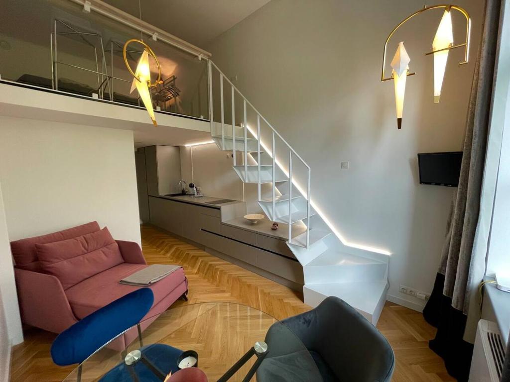 - un salon avec un escalier et un canapé rose dans l'établissement Cosy loft in Kaunas center, à Kaunas