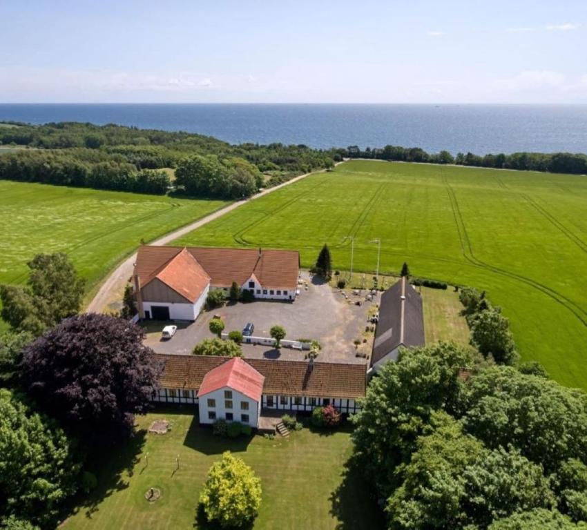 eine Luftansicht eines Hauses mit Meerblick im Hintergrund in der Unterkunft St. Strandbygaard in Åkirkeby