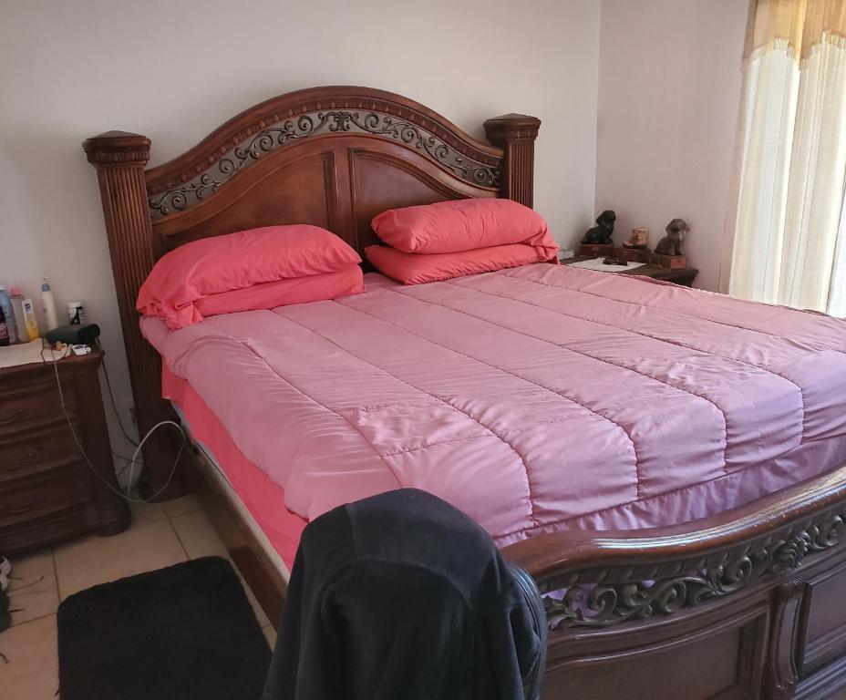 Una cama con dos almohadas rosas encima. en Missouri Holiday Homes LLC, 