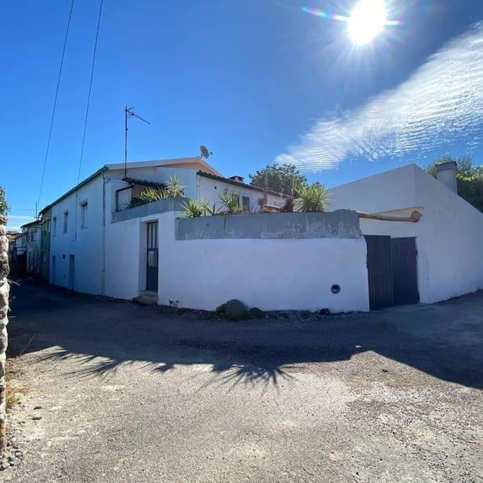 a white building with the sun in the sky at A Casa da Bicicleta in Lousã