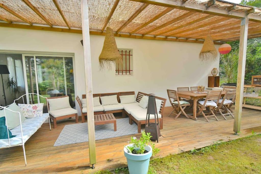 a patio with a wooden deck with a table and chairs at Maison basque avec jardin in Bidart