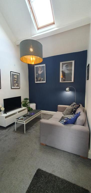 uma sala de estar com um sofá e uma televisão em Spring Cottage at Pen Y Coed Hall em Dolgellau