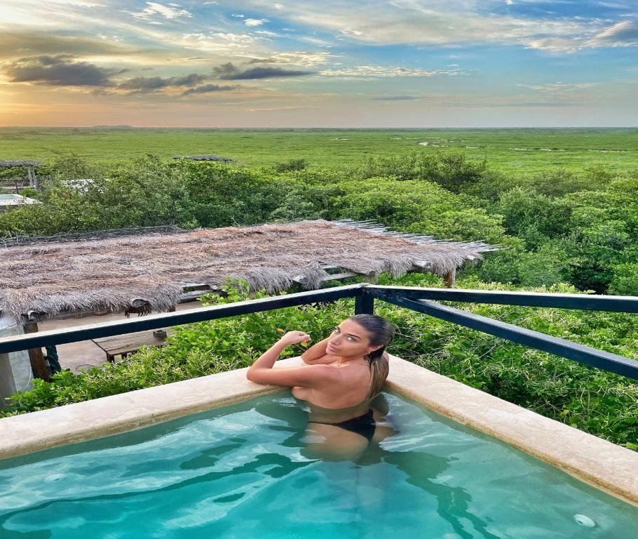 a woman in a swimming pool on a resort at Suites Tulum in Tulum