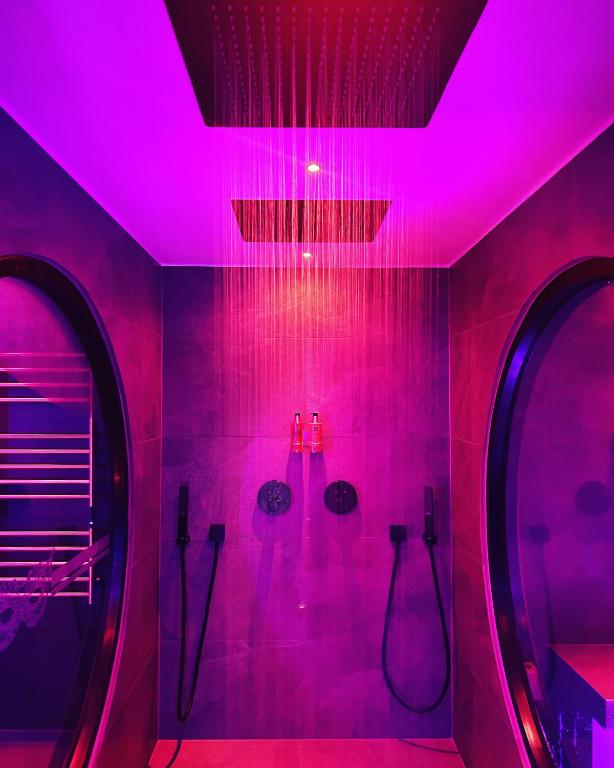 a bathroom with pink lights on the walls at LES SECRETS ROOMS - BONNEVILLE - LOVE ROOM 130m2 - SPA PRIVATIF in Bonneville