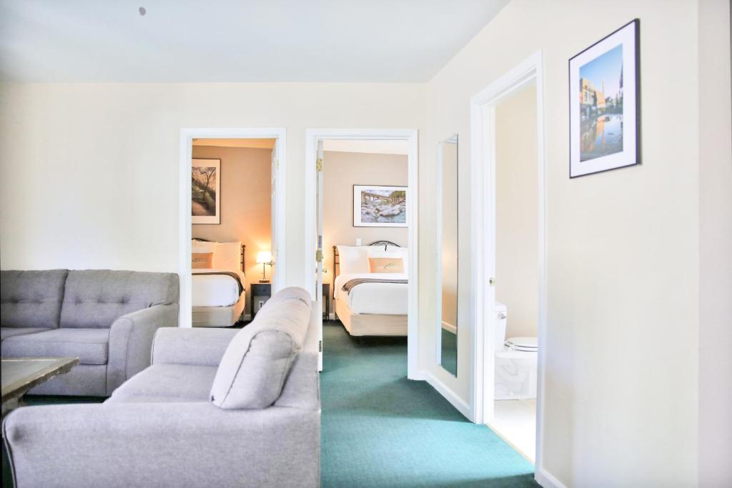 a living room with a couch and a bedroom at Sierra Mountain Inn in Grass Valley