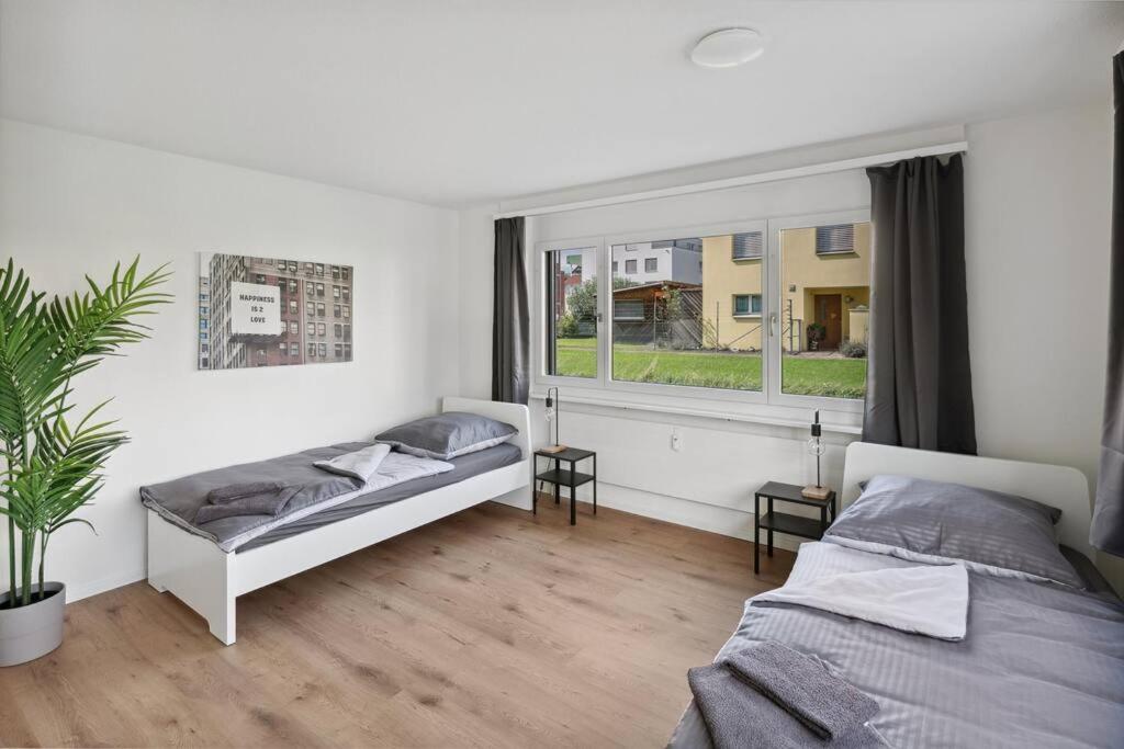 a bedroom with a bed and a large window at Geräumige Ferienwohnung in ruhiger Lage in Sennwald