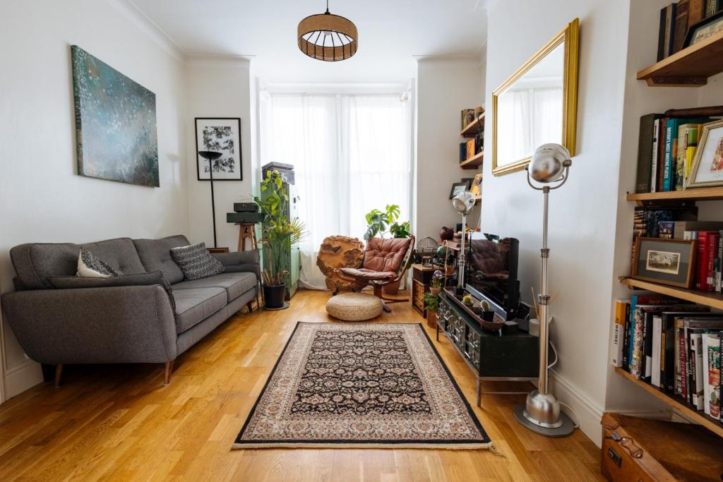 Hotel Unique private apartment w/ Easy access to Central London, a living room with a couch and a book shelf at Unique private apartment w/ Easy access to Central London in London