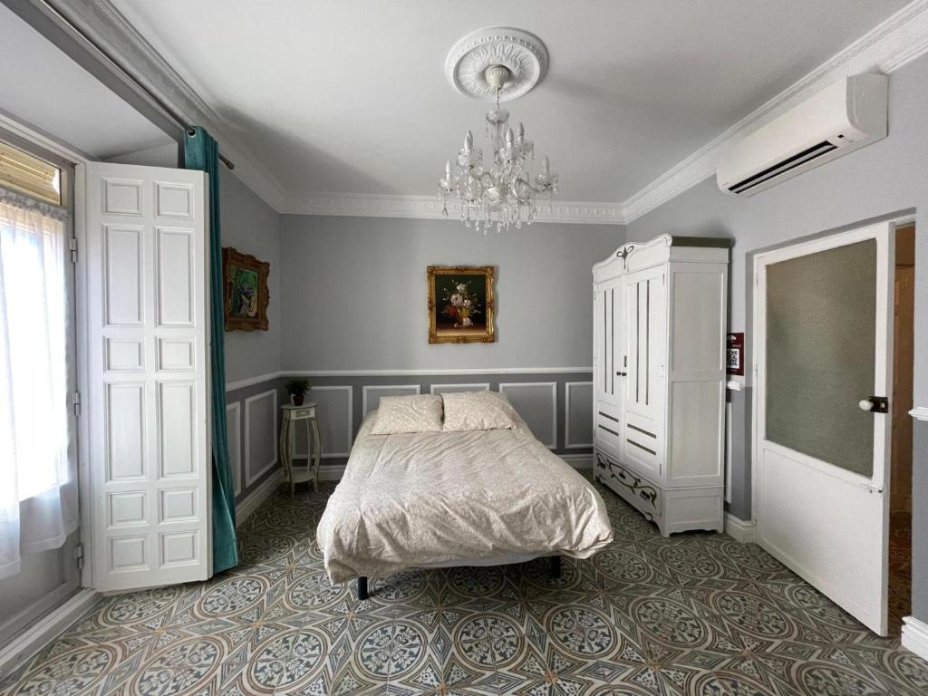 1 dormitorio con cama y lámpara de araña en Apartamento Trasiego, en Valdepeñas