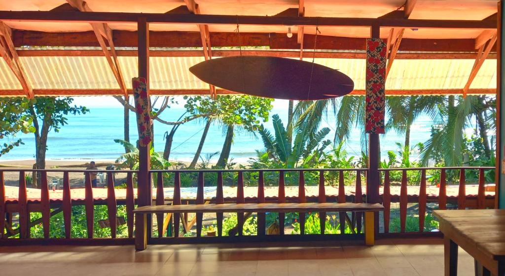 a view of the beach from a restaurant with a bench at Tortuguero Adventures Beach House in Tortuguero