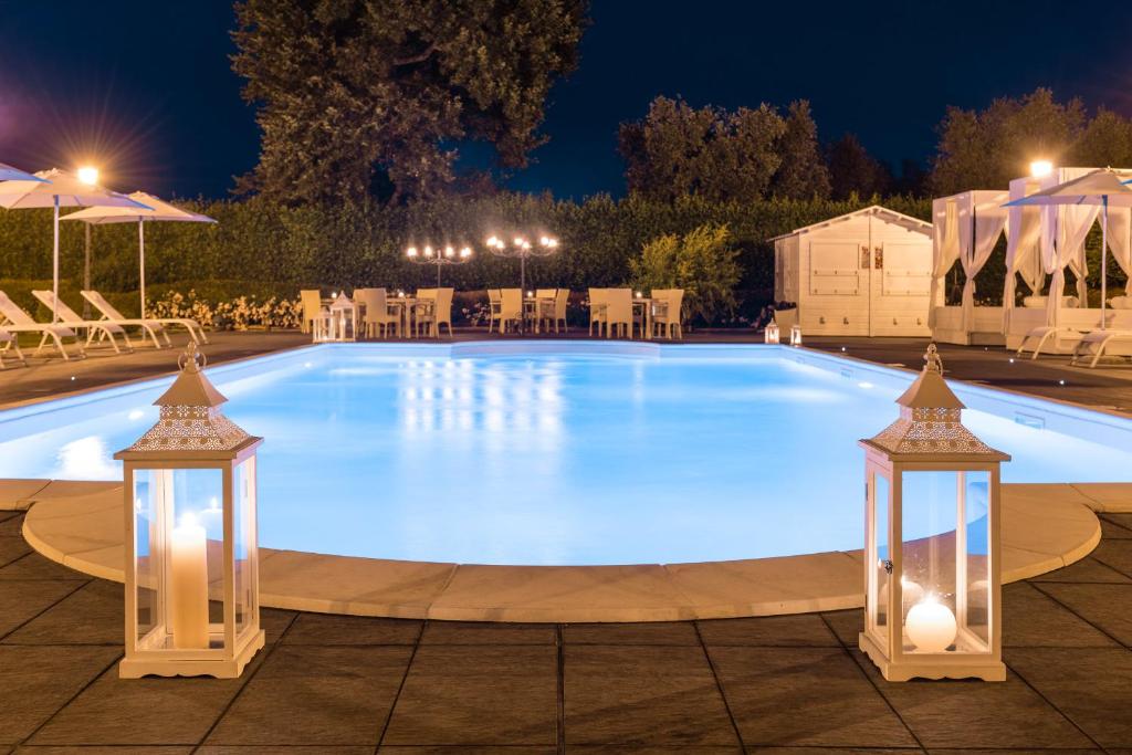 una grande piscina notturna con luci di Alla Corte Delle Terme Resort a Viterbo