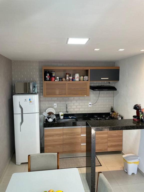 una cucina con frigorifero bianco e bancone di Apartamento 1 quarto Zona Sul Praia a Ilhéus