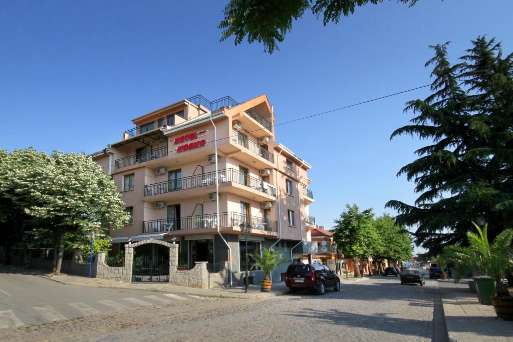 a building on a street with cars parked in front of it at Family Hotel Kosko in Chernomorets