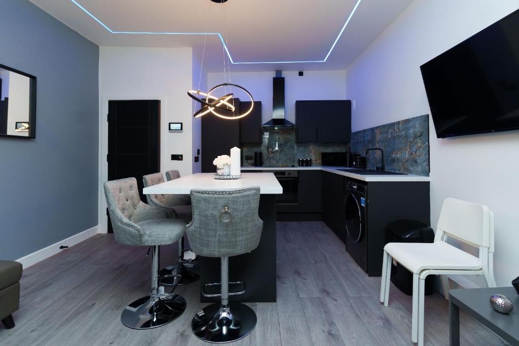 a kitchen with a table and chairs in a room at Hamilton Apartments in Leeds