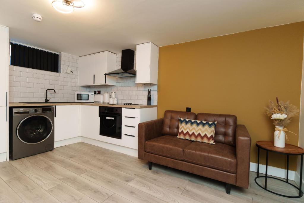 a living room with a couch and a kitchen at The Oasis Apartment in Leeds