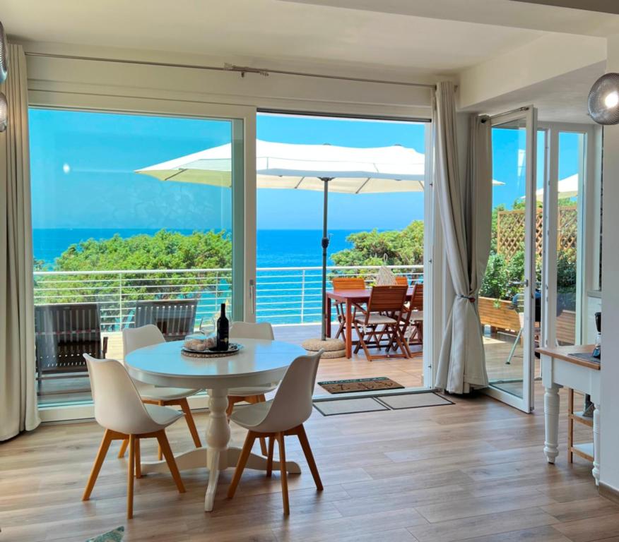 a living room with a table and chairs at ALBA stupendo appartamento in villa fronte Mare - Golfo dell'Asinara - Internet Free in La Ciaccia
