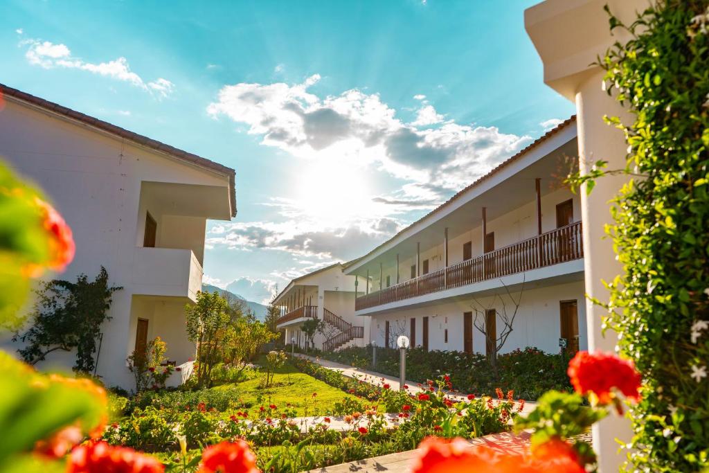 una fila di edifici con fiori in un cortile di Hotel Agustos Urubamba a Urubamba