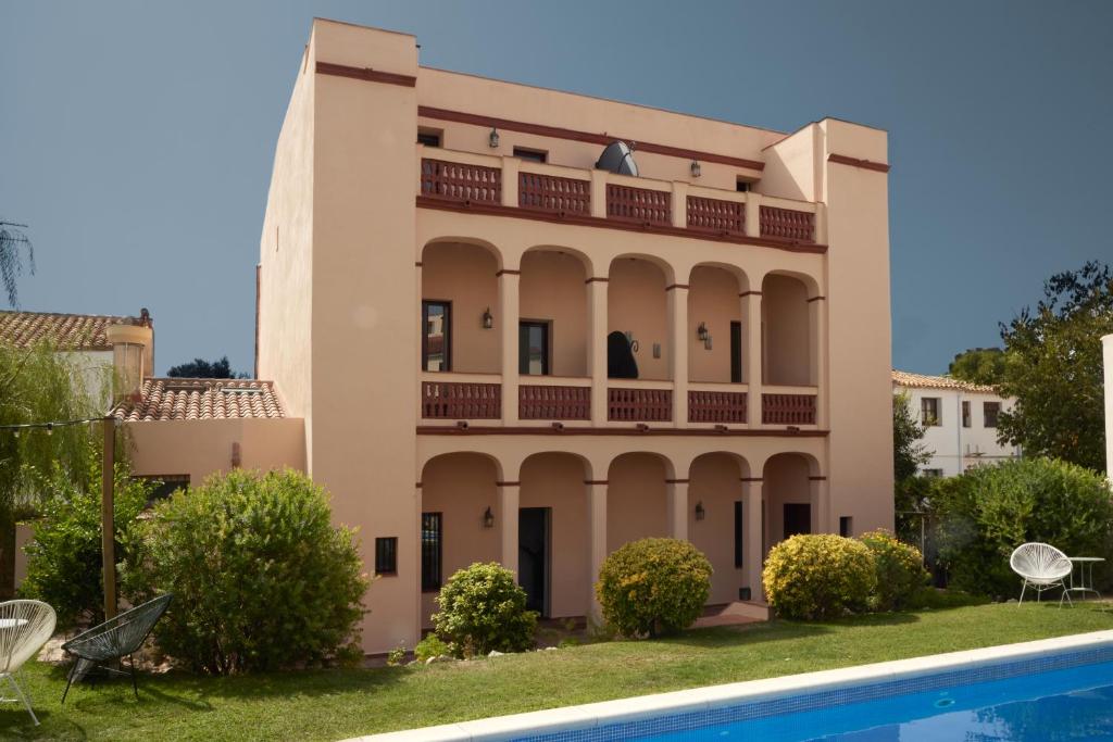 a house with a swimming pool in front of it at Hotel Palou 1874 in Sant Pere de Ribes