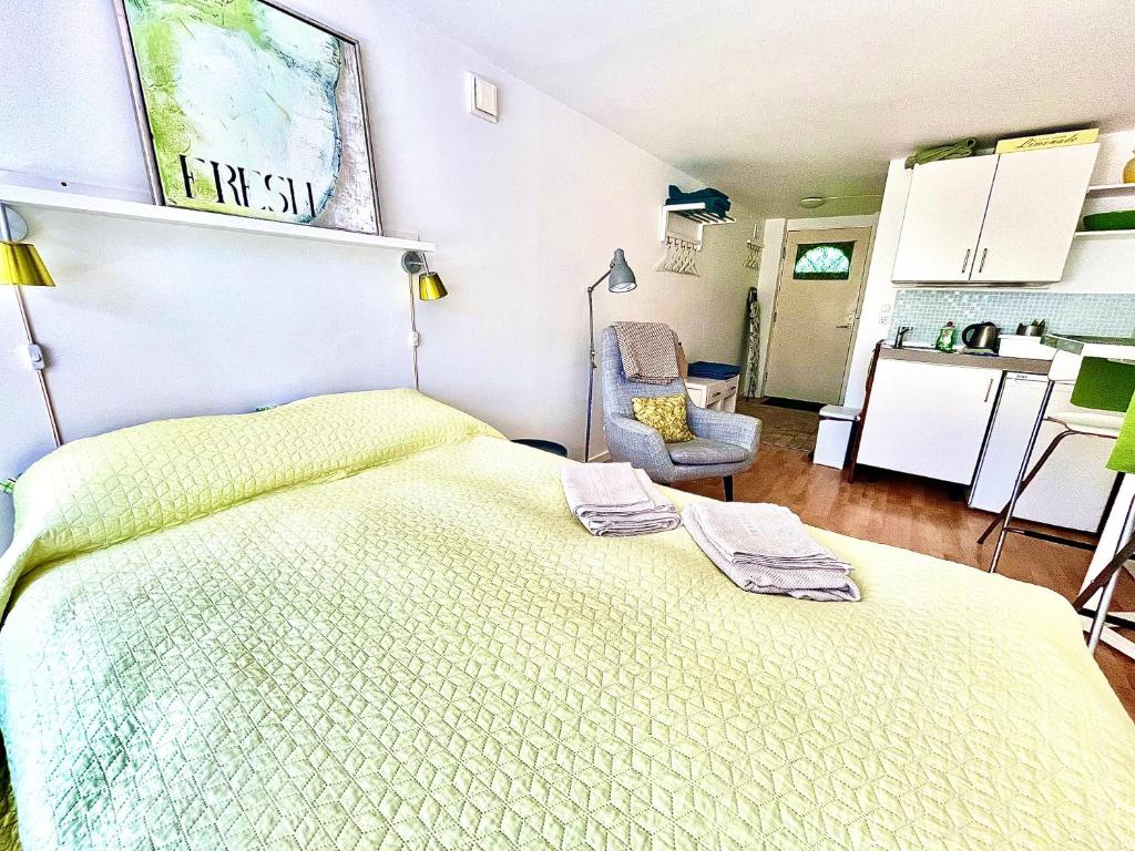 a bedroom with a large bed and a kitchen at Cosy apartment with private terrace in Vallensbæk