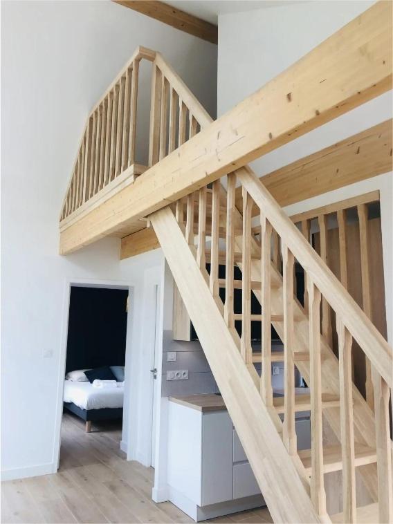 a wooden staircase in a room with a bed at La cabine du bout du monde avec Mezzanine PL08 -Le Creach, votre maison de vacances de haut standing in Crozon