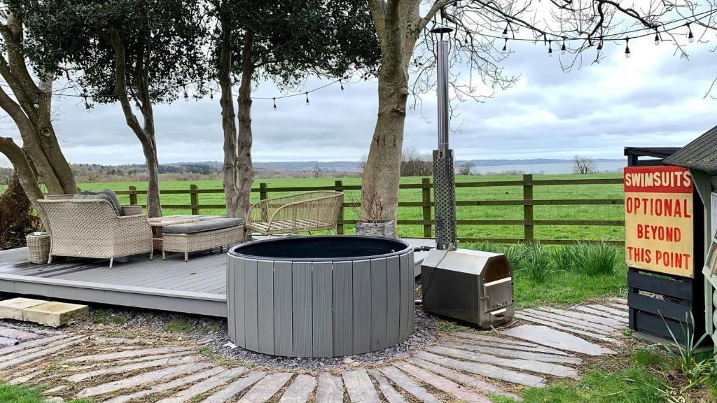 a fire pit and a tv on a deck at Tal Y Bont Uchaf Stables in Bangor