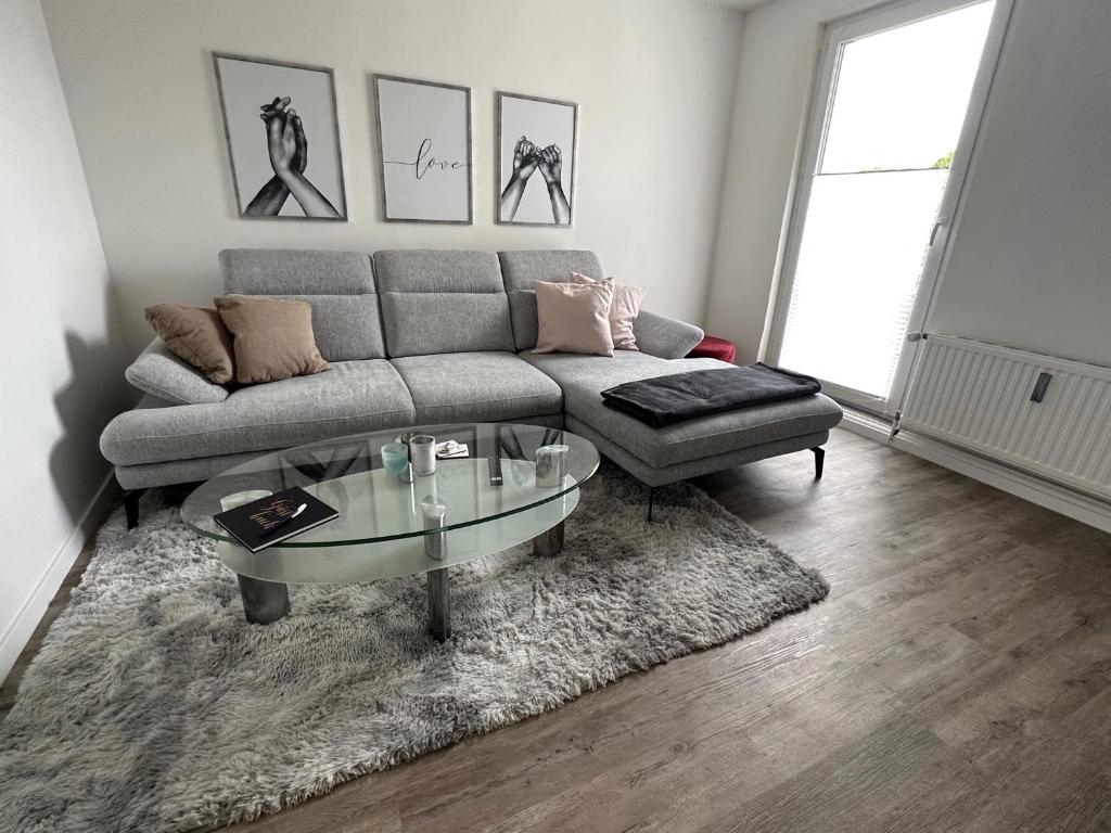 sala de estar con sofá y mesa de cristal en Seibels SUITES - Wohnung Ruhrgebiet en Herne