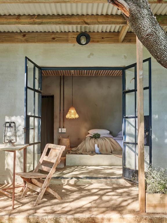 a bedroom with a bed and a table and a chair at FARMHOUSE58 in Krugersdorp