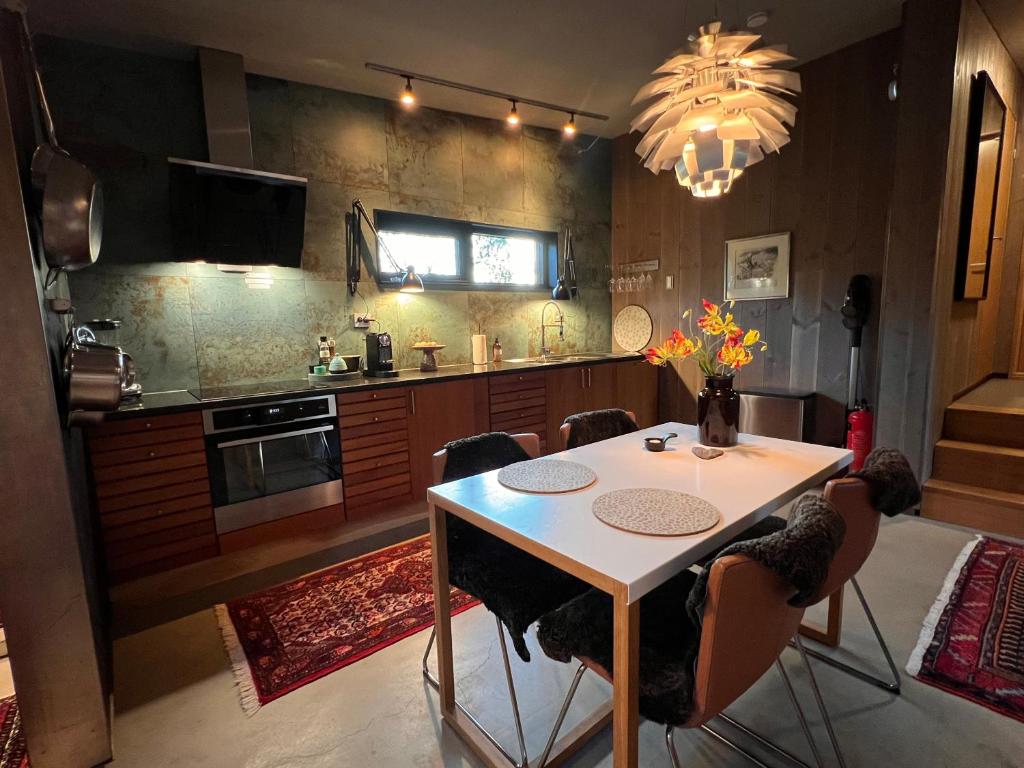 a kitchen with a table and chairs and a chandelier at Håkøya Lodge in Tromsø