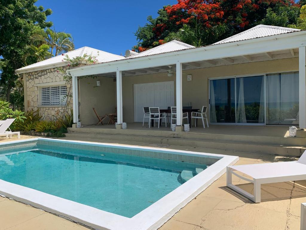 a swimming pool in front of a house at Villa Belvedere - 5 minutes walk to the Beach in Dickenson Bay