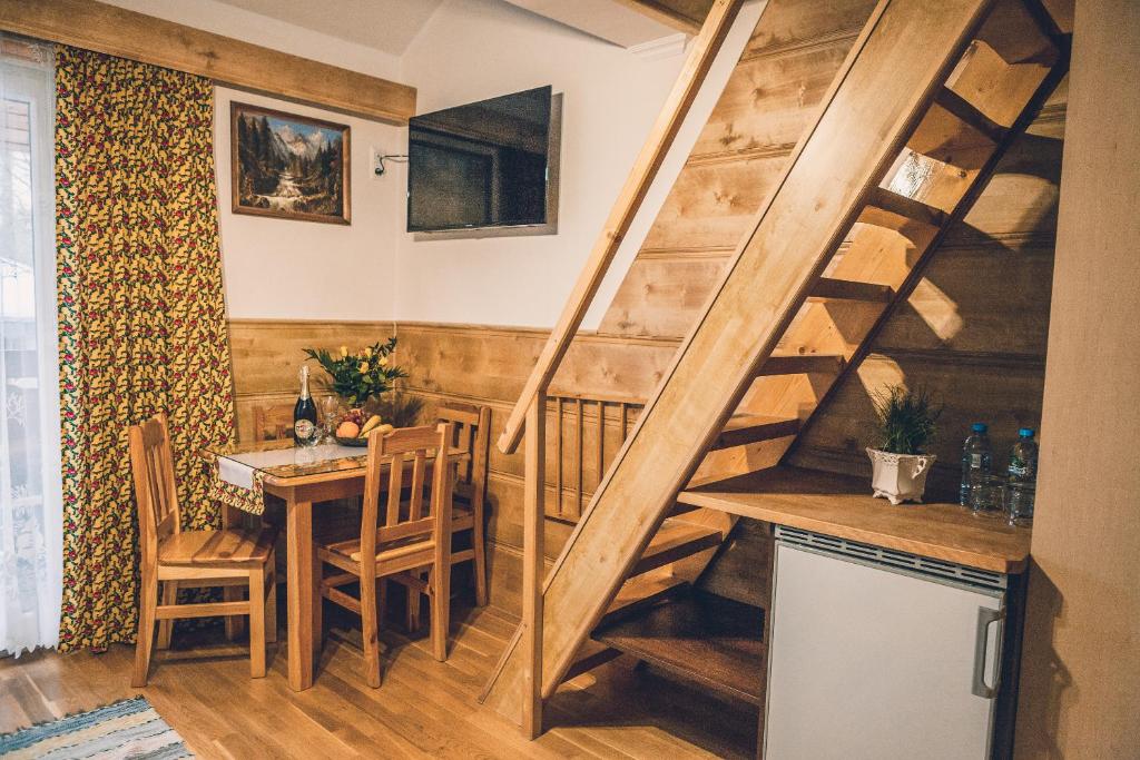 kuchnia i jadalnia z drewnianymi schodami i stołem w obiekcie Willa Szarotka w Rabce