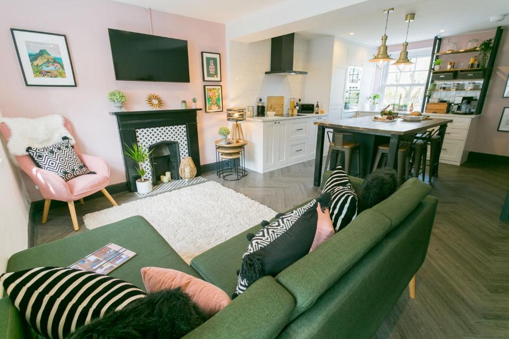 a living room with a green couch and a kitchen at 3 Greenfield Terrace in Menai Bridge